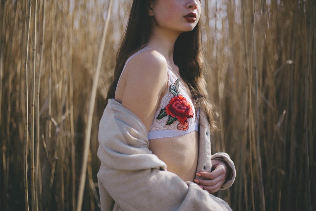 Une jeune femme portant un soutien-gorge brodé dans un champs